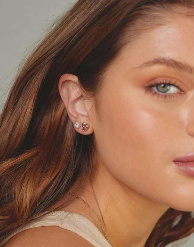 Close-up of a woman wearing earrings with a neutral background