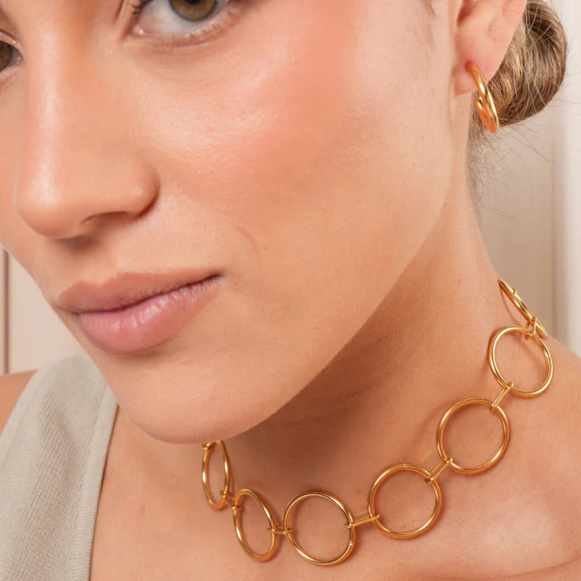 Close-up of a woman wearing a Circle Choker Golden Necklace.