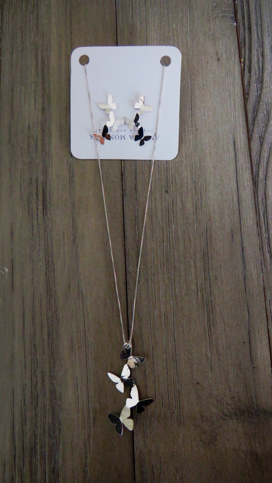 Necklace with a butterfly pendant on a wooden surface
