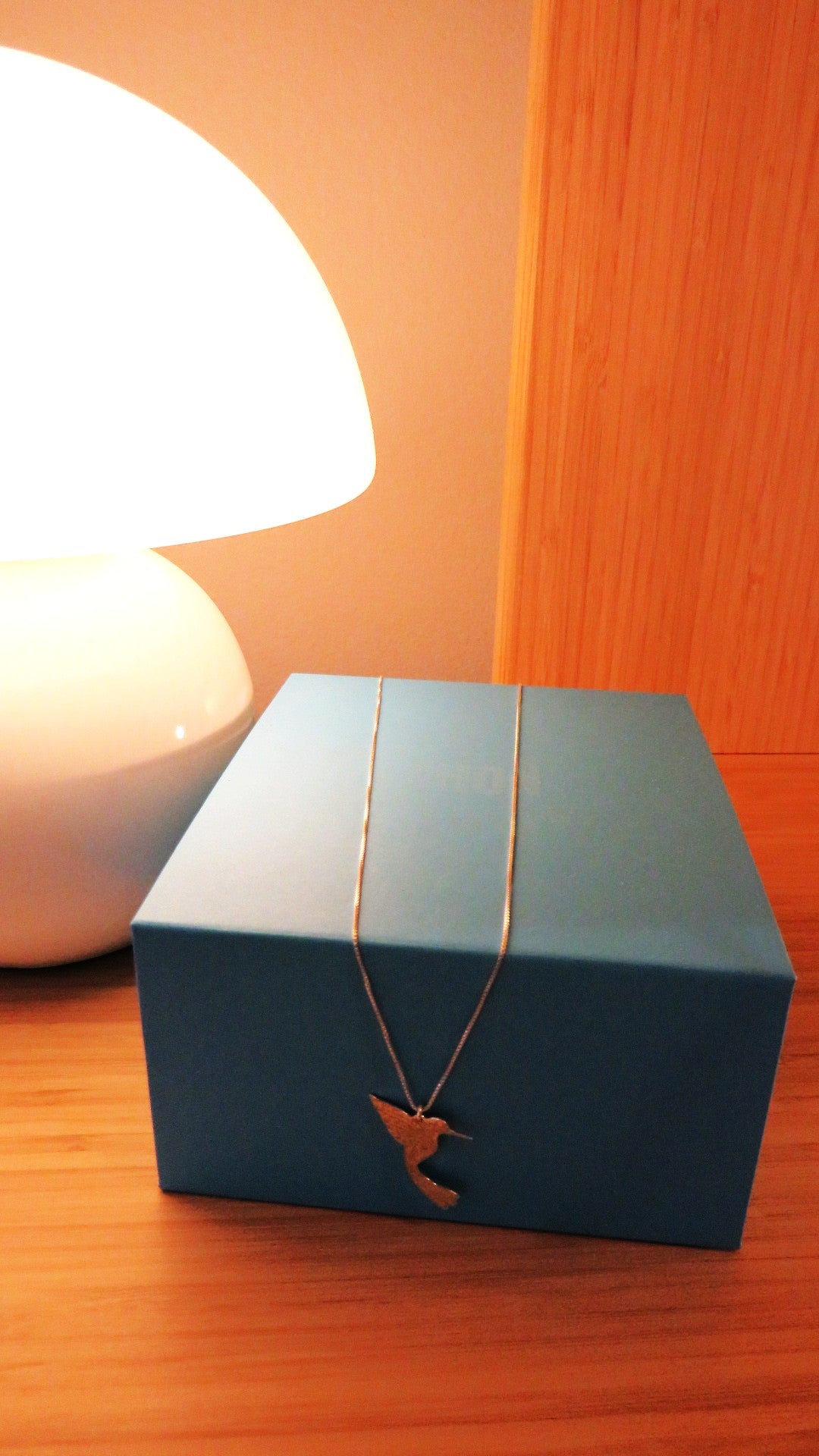 Blue jewelry box with a necklace on a wooden surface