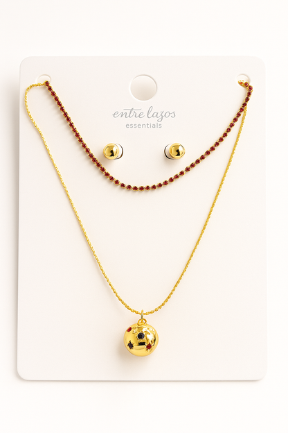 Gold necklace and earrings set on a white card with 'entre lados' branding.