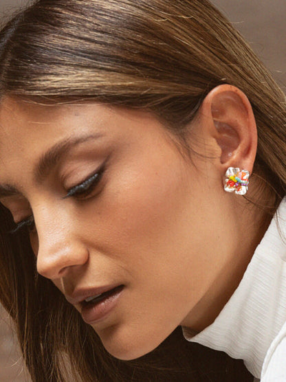 Close-up of a woman wearing colorful floral earrings.