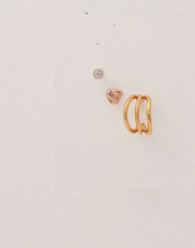 Gold ring and heart-shaped earring on a light gray background