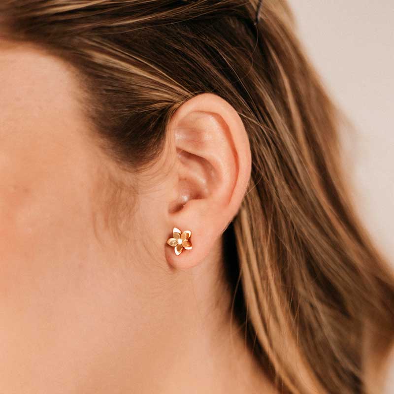 Guayacan Golden Stud Earrings worn by a person with light brown hair.