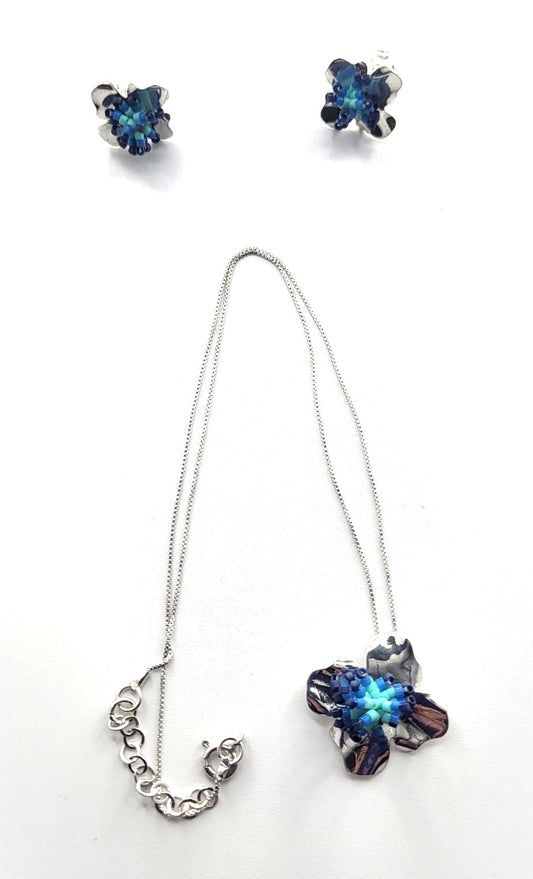 Jewelry set with necklace and earrings featuring blue gemstones on a white background