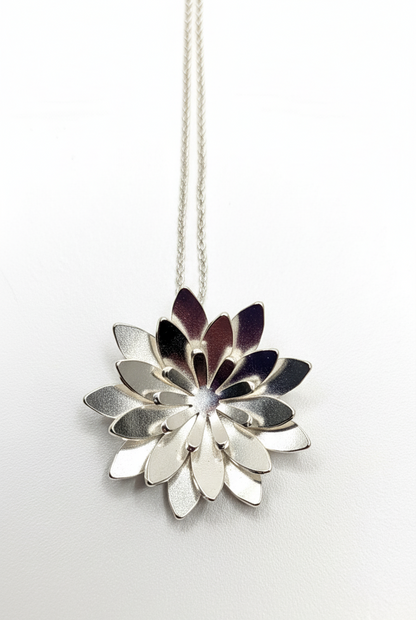 Silver loto flower-shaped pendant on a white background