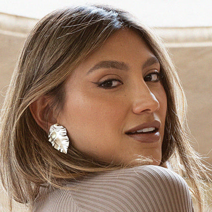 Close-up of a woman wearing a large, decorative earring.