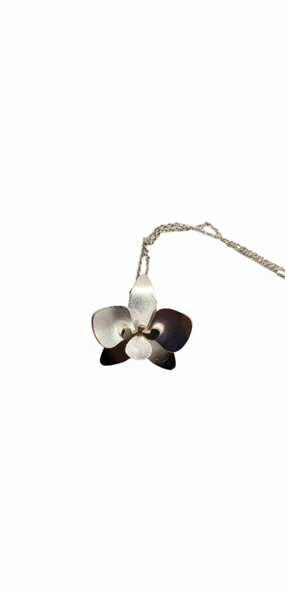 Silver necklace with a unique orchid-shaped pendant on a white background