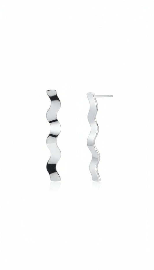 Silver wavy earring worn by a person with a blurred background