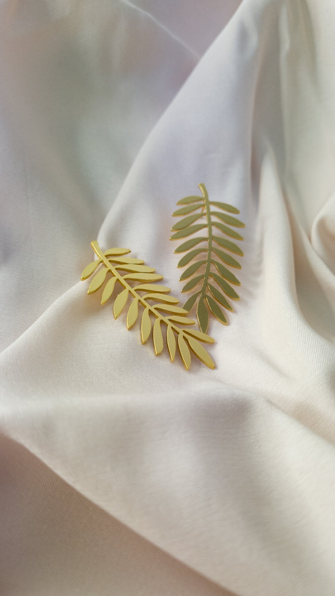 Palm Golden Earrings on a white fabric background