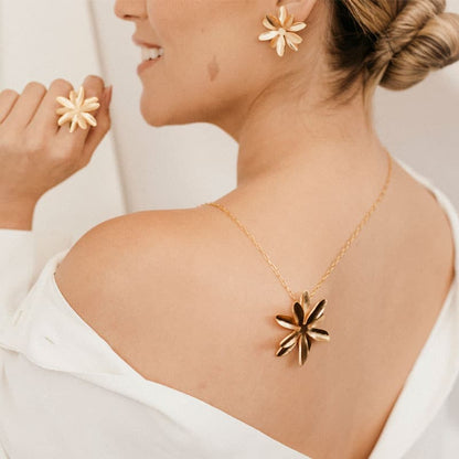 Woman wearing Passiflora Golden Stud Earrings with a plain background