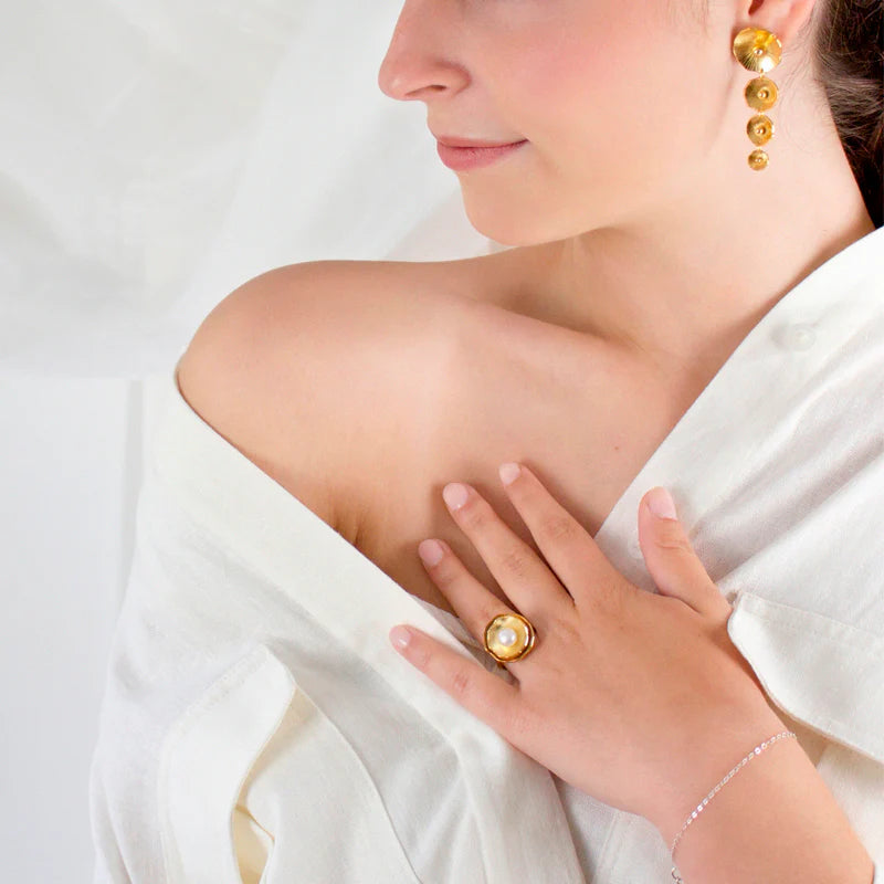 Woman wearing Renacer golden ring, with a white background