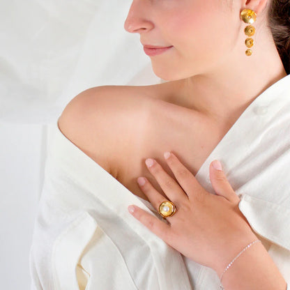 Woman wearing Renacer golden ring, with a white background