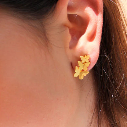 Close-up of an ear wearing Triple Butterfly Golden Earrings