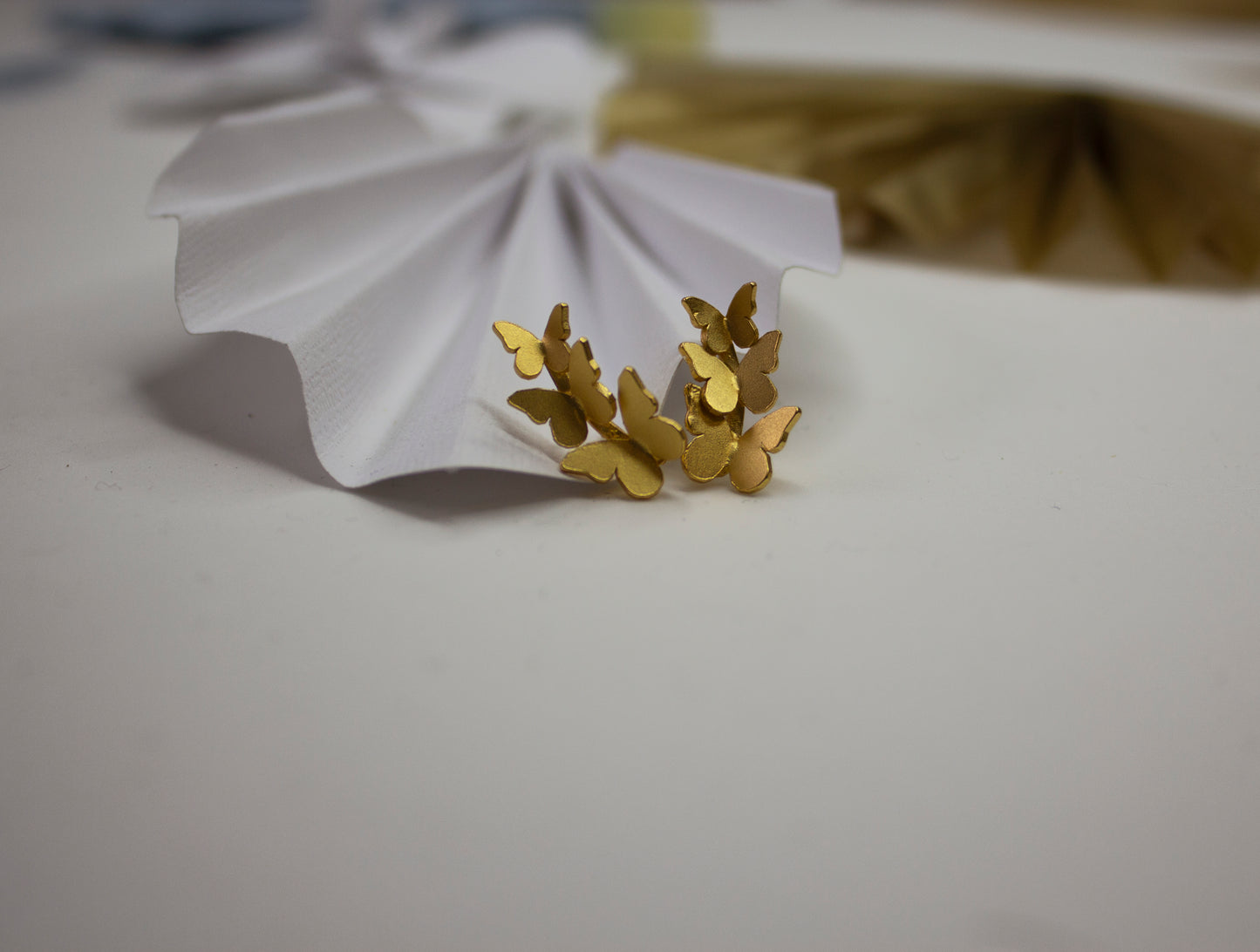 Triple Butterfly Golden Earrings on a white paper